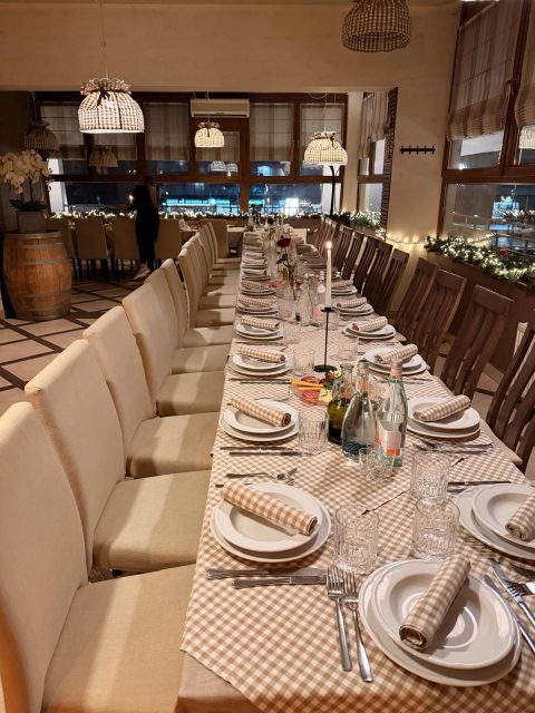 Sala restauracji z długim stołem nakrytym obrusem w kratkę